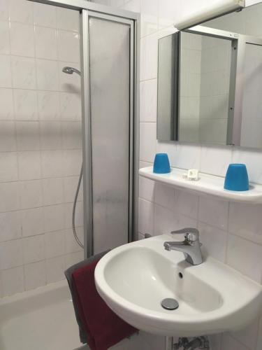 a white bathroom with a sink and a shower at Oranienblick in Gückingen