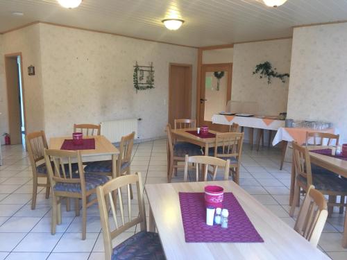 un restaurante con mesas y sillas con servilletas moradas. en Oranienblick, en Gückingen