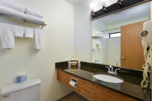a bathroom with a sink and a mirror and a toilet at Cap Sante Inn in Anacortes