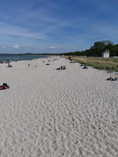 a group of people laying on a sandy beach at Gutshaus Thorstorf FeWo Boltenhagen EG und Tiefpaterre in Warnow