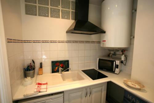 a small kitchen with a sink and a microwave at Appartement Opéra Paris in Paris