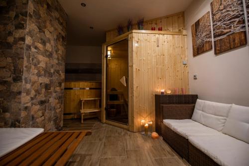 a room with a sauna with a couch and a table at Penzion u Vichu in Červená Voda