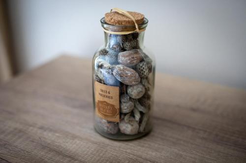 a glass jar filled with stones on a wooden table at Annona Apartments in Bečej