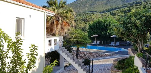 a house with a staircase leading to a swimming pool at Diogenis Parga Studios in Parga