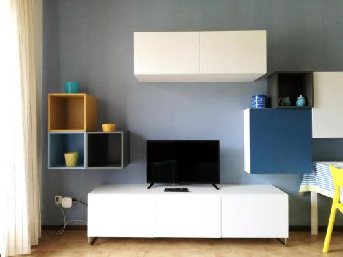 een woonkamer met een tv op een witte kast bij Appartamento Ivrea Centro - Sito UNESCO in Ivrea