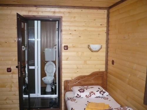 een kleine slaapkamer met een bed en een toilet bij Guest House Chobaka in Trigrad