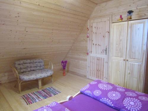 Zimmer mit einem Bett und einem Stuhl im Dachgeschoss in der Unterkunft rekreační dům levandule in Jince