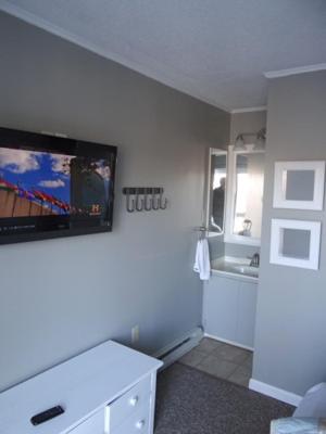 a bathroom with a tv on a white wall at Winterplace Condo Ski in Ski out First Floor E102 in Ghent