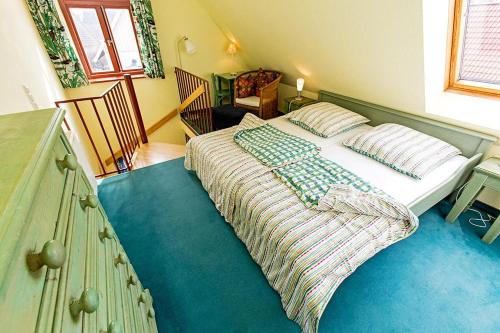um quarto com uma cama com uma cabeceira verde em Ferienhaussiedlung Strandperlen Sanddornhof 2d (Typ I) em Wustrow