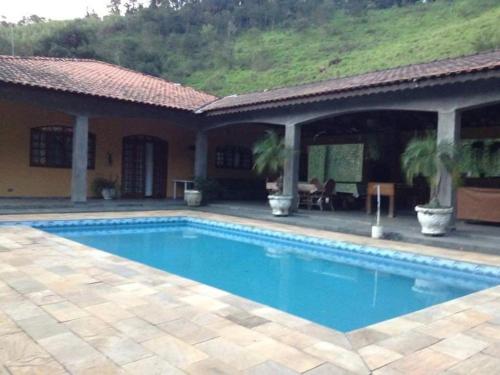 a swimming pool in front of a house at Fazenda Carpas Douradas in São Roque
