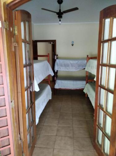 a room with three beds in a room with doors at Fazenda Carpas Douradas in São Roque