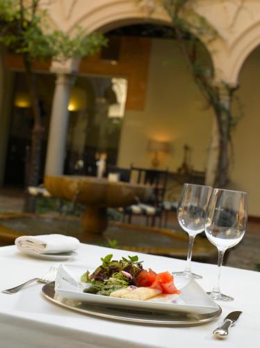 a plate of food on a table with two wine glasses at Parador de Granada in Granada