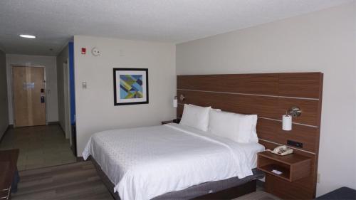a hotel room with a bed and a telephone at Holiday Inn Express Hotel & Suites Greensboro-East by IHG in Greensboro