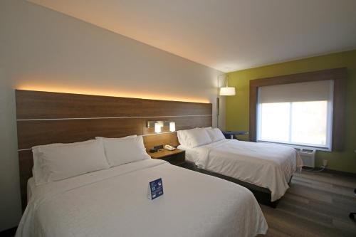 a hotel room with two beds and a window at Holiday Inn Express Hotel & Suites Greensboro-East by IHG in Greensboro