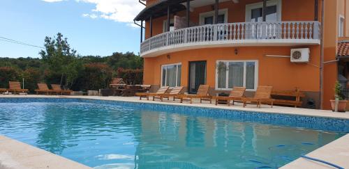a swimming pool in front of a house at Apartments Šeherzada in Pula