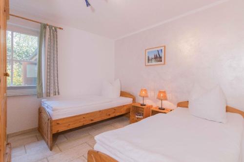 ein Schlafzimmer mit zwei Betten und einem Fenster in der Unterkunft Haus WINDFLÜCHTER Whg. LF 6.1 in Wustrow