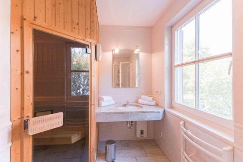 ein Badezimmer mit Waschbecken, Spiegel und Fenster in der Unterkunft Haus WINDFLÜCHTER Whg. LF 6.1 in Wustrow