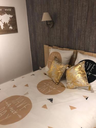 a bed with white sheets and gold pillows on it at Auberge des platanes in Villevocance