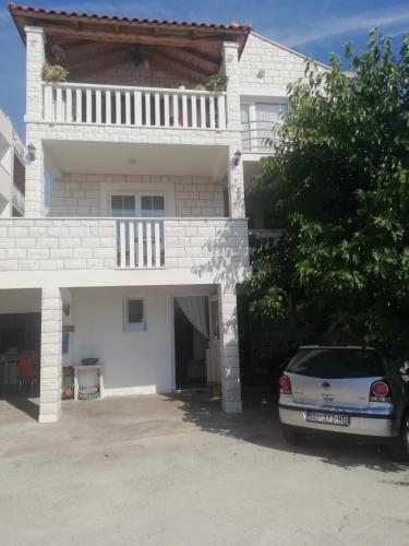 a white house with a car parked in front of it at Guesthouse Alliya in Dubrovnik