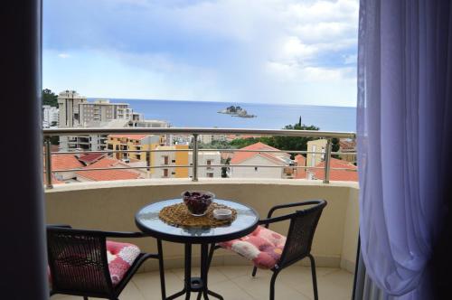 a table on a balcony with a view of the ocean at Panorama Petrovac in Petrovac na Moru