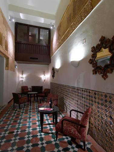 a lobby with chairs and a table in a room at Parador de Granada in Granada