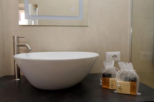 a white bowl sitting on a counter in a bathroom at Il Borgo Luxury Suites in Nettuno