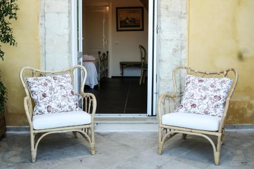 two chairs with pillows sitting on a porch at Bed and Breakfast Terra del Sole Ibla in Ragusa
