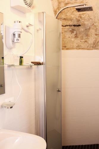 a bathroom with a shower with a toilet and a sink at Bed and Breakfast Terra del Sole Ibla in Ragusa