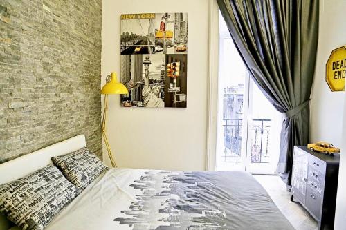 ナポリにあるM99 Design Roomsのレンガの壁、ベッド付きのベッドルーム1室