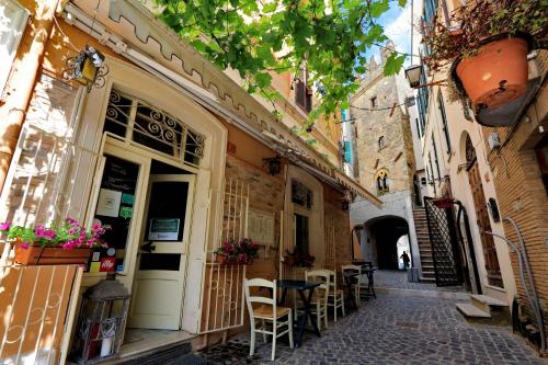 an alley with tables and chairs outside of a building at Il Borgo Luxury Suites in Nettuno