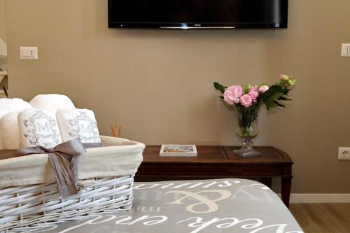 a living room with a table with a vase of flowers at Il Borgo Luxury Suites in Nettuno