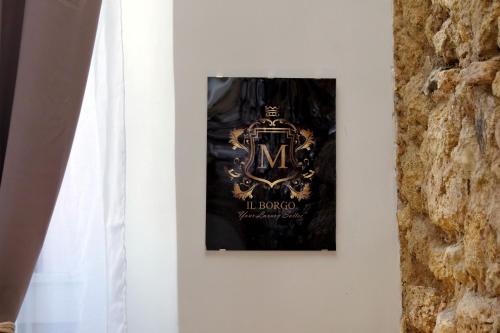 a picture hanging on a wall next to a window at Il Borgo Luxury Suites in Nettuno