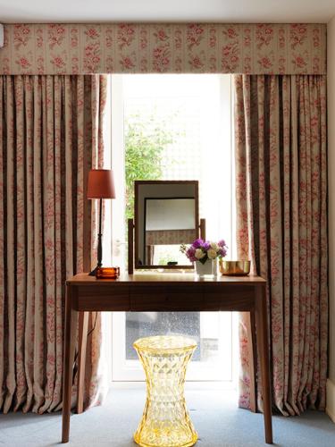 a table with a mirror in a room with a window at Cheval Knightsbridge in London