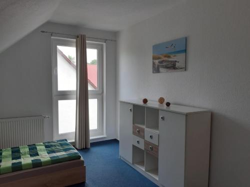 a bedroom with a bed and a dresser and a window at DA Ferienwohnungen in Bargischow