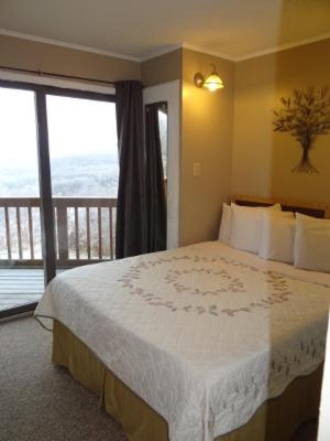 a bedroom with a large bed and a balcony at Winterplace Ski in Ski out condo First Floor D103 in Ghent