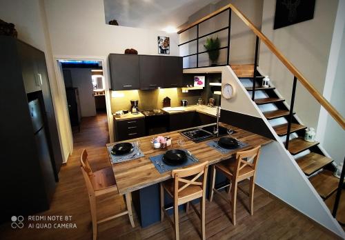 een kleine keuken met een tafel en een trap bij Key for Kiato House-Modern Loft design in Kiáton