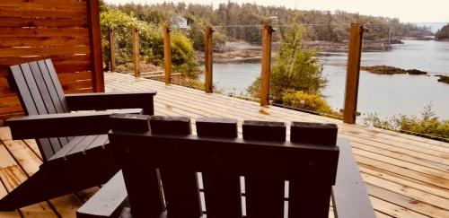 a wooden deck with a bench and a view of a river at 378 Marine Drive in Ucluelet