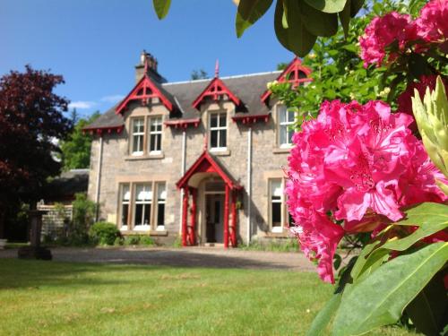 una casa con flores rosas delante de ella en Annslea Guest House en Pitlochry