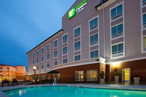 a hotel building with a pool in front of it at Holiday Inn Express & Suites - Valdosta by IHG in Valdosta