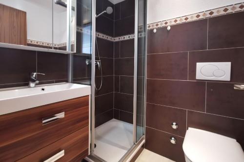 a bathroom with a shower and a toilet and a sink at Leukerbad Holiday Home in Leukerbad