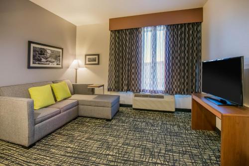 a living room with a couch and a flat screen tv at La Quinta by Wyndham Morgantown in Morgantown