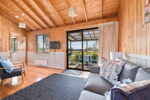 a living room with a couch and a television at Hazelcreek Cottages in Exeter