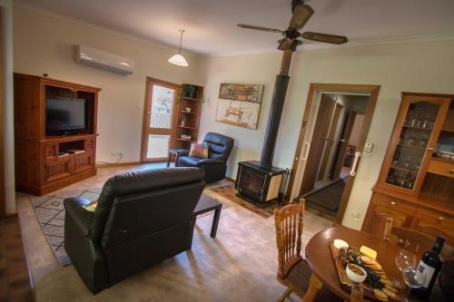 a living room with a couch and a stove at Glenlee Cottage in Wall Flat