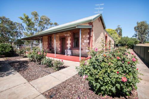 a brick house with flowers in front of it at Glenlee Cottage in Wall Flat