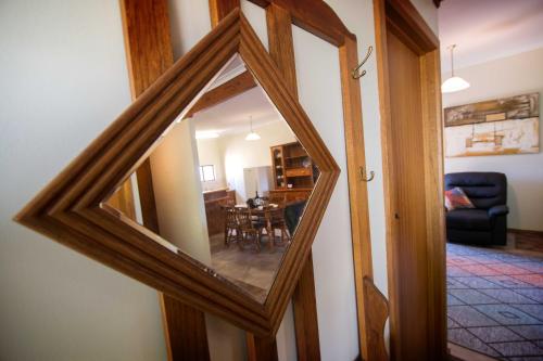 a mirror reflecting a living room and a dining room at Glenlee Cottage in Wall Flat
