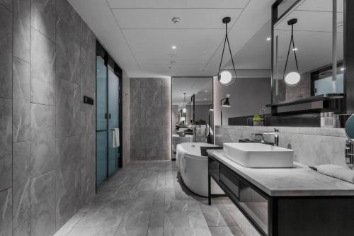 a bathroom with a tub and a sink and a tub at Qingdao Treasure Hotel in Qingdao