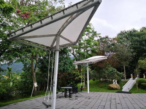 a pavilion with a table and an umbrella in a park at Khokak Panoramas Hotel in Gukeng