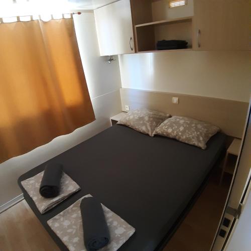 a small room with a bed and a table at Grand Veles camp in Pula