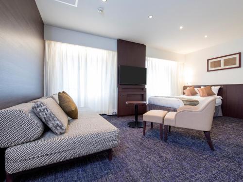 a hotel room with a bed and a couch at HOTEL MYSTAYS Fukuoka Tenjin in Fukuoka