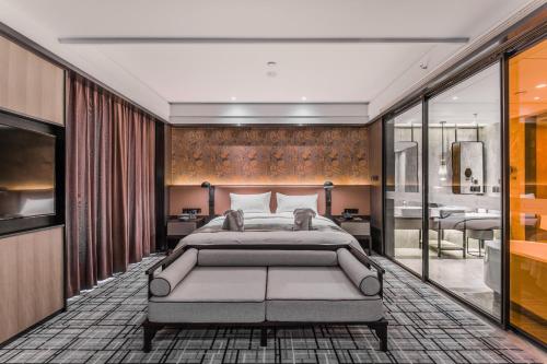 a bedroom with a large bed and a bathroom at Qingdao Treasure Hotel in Qingdao